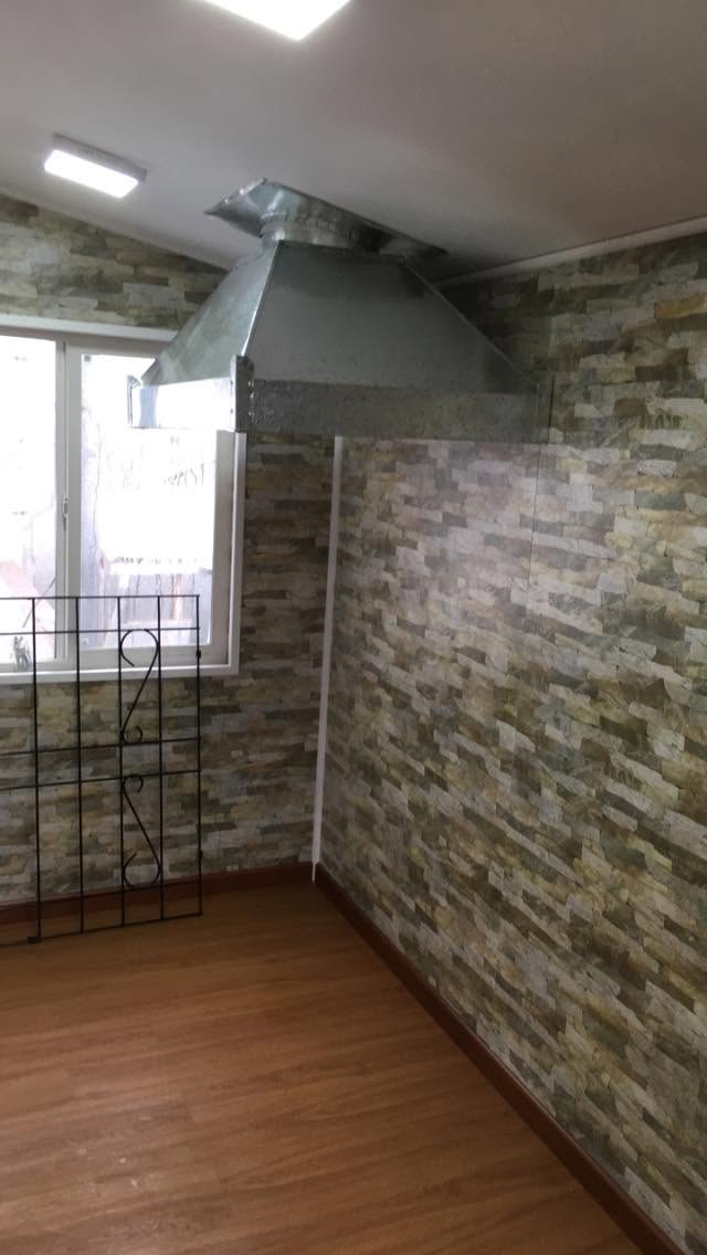 Revestimiento de piedra y campana en cocina remodelada